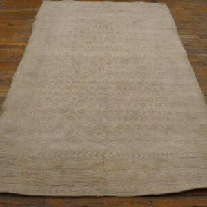 A light beige, subtly patterned rug lying on a rustic wooden floor by Rugs On Net. by Rugs On Net