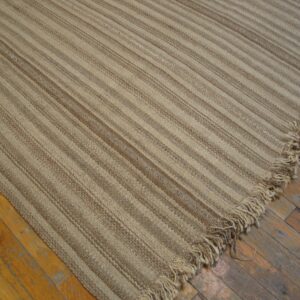 Close-up of a beige striped jute rug on wood floors by Rugs On Net