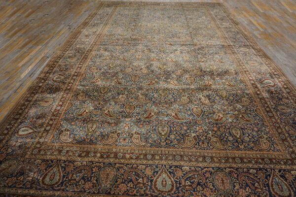 A large, antique persian rug featuring an all-over paisley pattern on a deep blue field, by rugs on net. By rugs on net