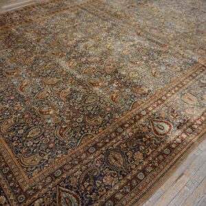 Close-up of a richly patterned, antique Persian rug featuring dense paisley motifs on a dark blue field, by Rugs On Net