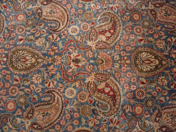 Close-up of a blue field persian rug with repeating paisley motifs by rugs on net