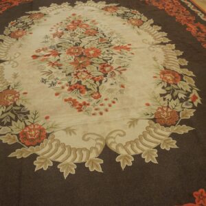 Oval floral rug with orange and cream details on a dark brown field by Rugs On Net