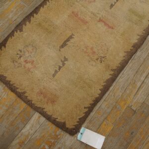 Close-up of a beige and brown hooked rug texture on a distressed wooden floor by Rugs On Net