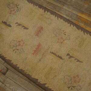 Close-up of a beige rug with subtle floral and geometric patterns, featuring a dark brown serrated border, resting on rustic wooden flooring by Rugs On Net. by Rugs On Net