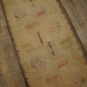 Close-up of a beige rug with faded pink floral motifs on distressed wood flooring by Rugs On Net. by Rugs On Net