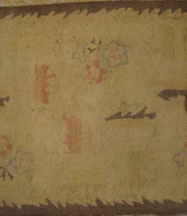 Close-up of a beige hooked rug with faded floral motifs and a dark brown serrated border by rugs on net. By rugs on net