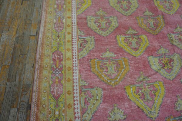 Close-up of a pink and yellow patterned rug next to wooden floorboards by rugs on net