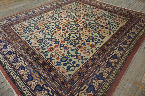 Close-up of a vintage area rug featuring cream field with blue and coral floral motifs and intricate borders, by rugs on net