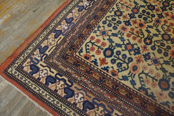Close-up corner detail of an antique floral rug featuring beige, blue, and coral tones on a distressed wooden floor by rugs on net