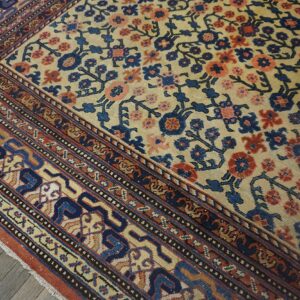 Close-up of a traditional rug with a beige field, blue, and coral floral pattern, showing detailed border work by Rugs On Net. by Rugs On Net