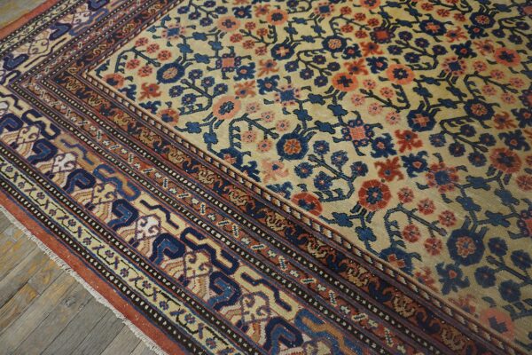 Close-up of a traditional rug with a beige field, blue, and coral floral pattern, showing detailed border work by rugs on net. By rugs on net