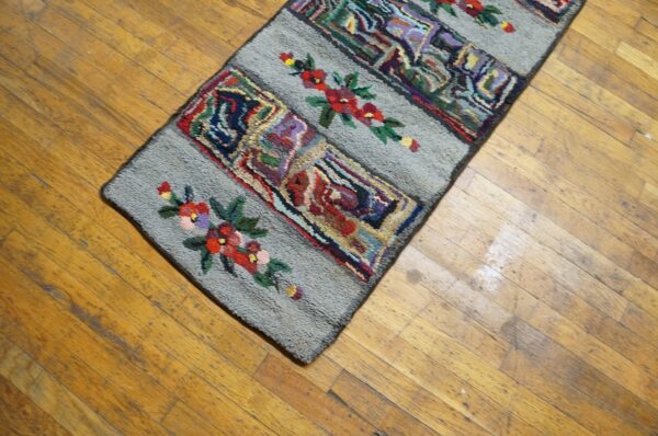 Close-up of a colorful hooked rug runner with floral accents on a wooden floor by rugs on net