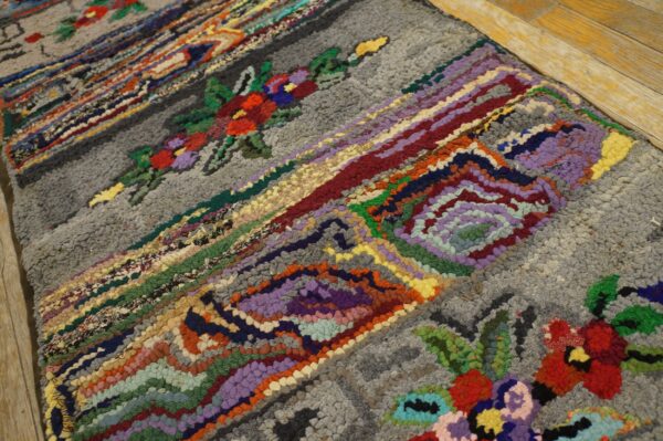 Close-up of a colorful hooked rag rug with floral accents on a gray background, by rugs on net