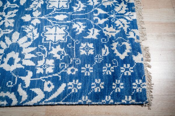 Blue ivory oushak rug corner and fringe detail