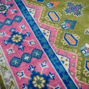 Green and fuchsia Kazak rug border and field close-up