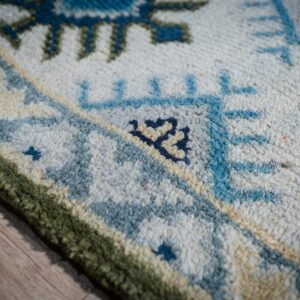 Light green beige Kazak rug border close-up