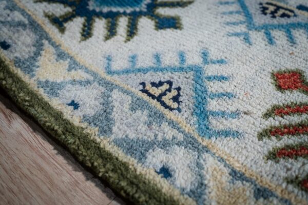 Light green beige kazak rug border close-up