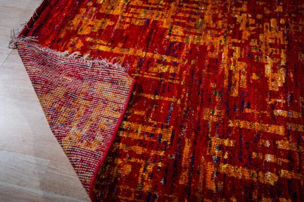 Sari-silk red abstract anand rug corner folded showing the back