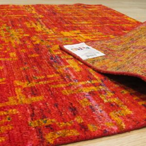 Anand rug folded corner showing the hand-knotted back and label