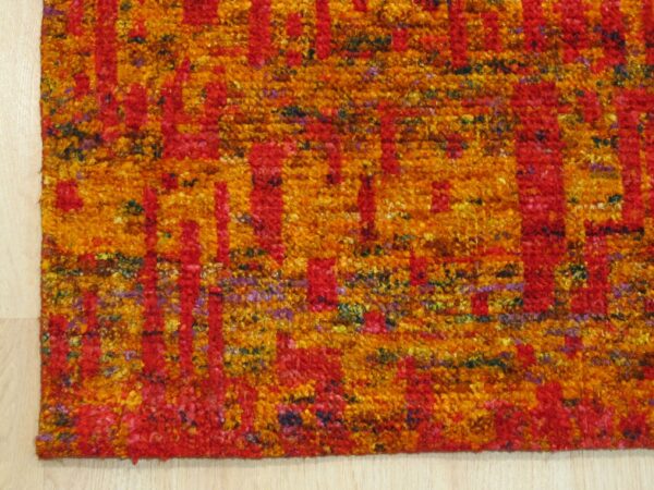 Close-up of anand rug recycled sari-silk pile texture in red and gold