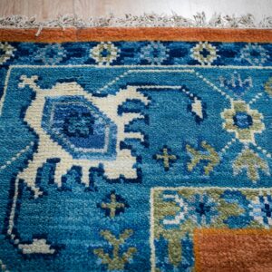 Rust blue Kazak rug blue border close-up