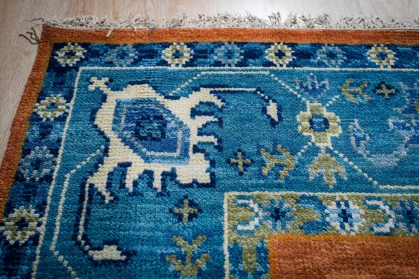 Rust blue kazak rug blue border close-up