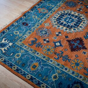 Rust blue Kazak rug corner and blue border detail