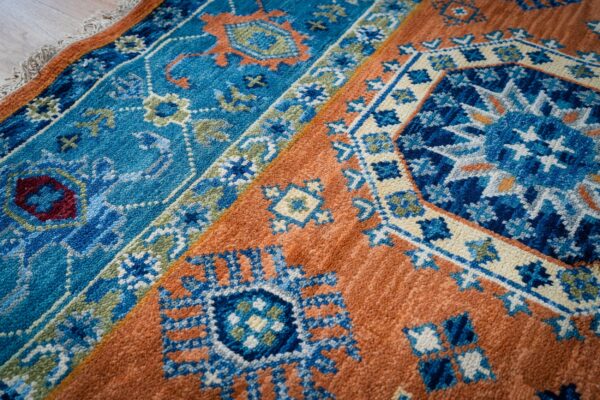 Rust blue kazak rug field and border detail