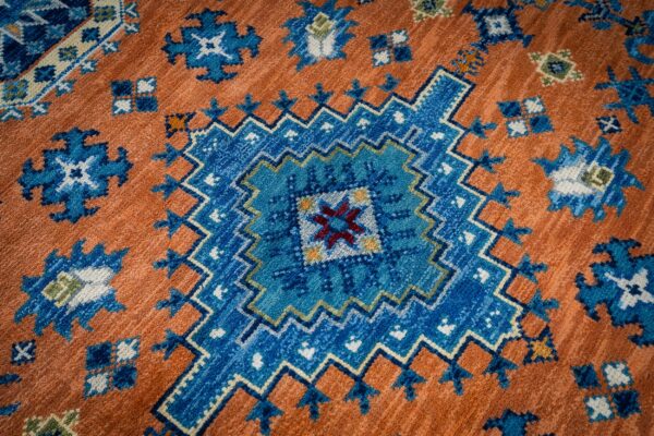 Rust blue kazak rug central medallion close-up