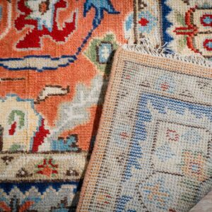 Rust Oushak rug corner folded showing the back