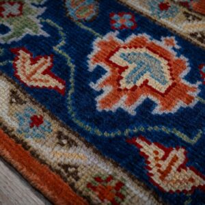 Rust Oushak rug navy border motif close-up