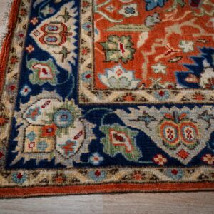 Rust Oushak rug corner and navy border detail