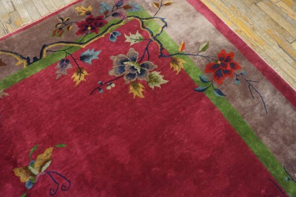 Antique red color classic chinese art deco design room size carpet 11 Corner of a red chinese art deco carpet with a dark branch bearing red and blue blossoms and a butterfly above the taupe border