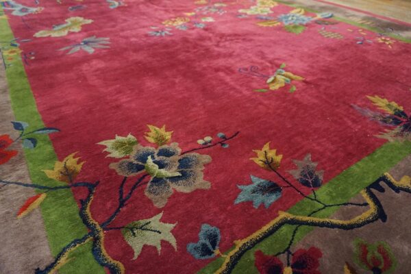 Antique red color classic chinese art deco design room size carpet 2 Corner detail of a red chinese art deco rug showing a teal peony, olive and cream leaves and a dark flowering branch against the green inner frame