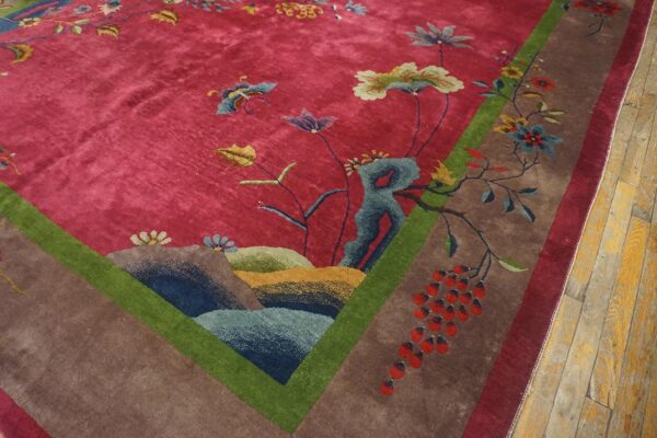 Antique red color classic chinese art deco design room size carpet 5 Corner detail of a red art deco chinese carpet on wood flooring, with blue-green rockwork and a cluster of red berries beside the green frame