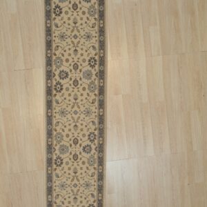 Charming Oushak ivory and blue hand knotted wool hallway runner rug shown full length on light wood flooring