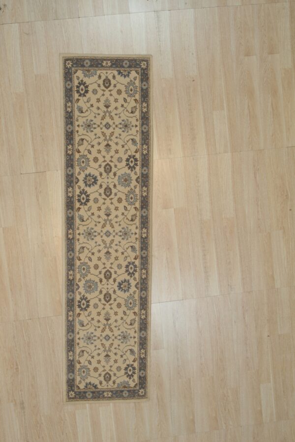 Charming oushak ivory and blue hand knotted wool hallway runner rug shown full length on light wood flooring