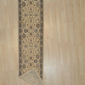 Ivory and slate blue Oushak wool runner rug with a corner folded back to show the hand knotted pile and backing