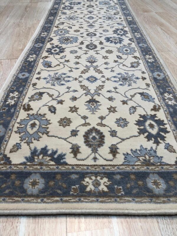 Close up of the ivory field and slate blue floral border on the charming oushak hand knotted wool runner rug