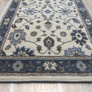Detail of the blue, brown and cream palmette and vine pattern on the Charming Oushak ivory wool runner rug