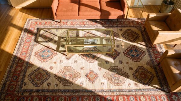 Ivory large scale primitive tribal pattern antique persian bakshaish rug (sku 24481) - styled overhead view