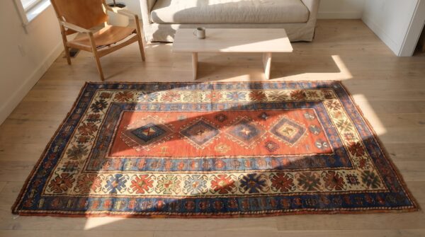 Red rustic antique tribal geometric pattern caucasian kazak rug (sku 17766) - styled overhead view
