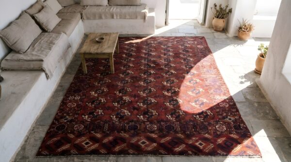 Red antique turkman tekke tribal geometric bokhara design rug (sku 22769) - styled overhead view