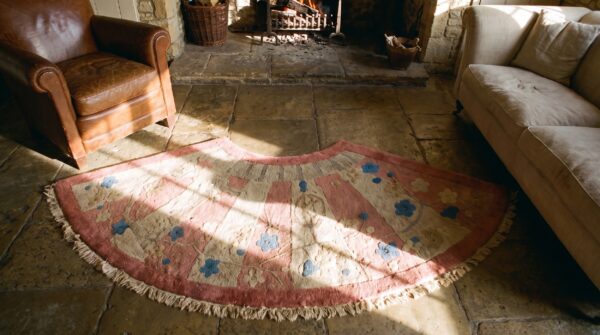Round 1920s hand knotted pile wool coral antique rug 2 Round 1920s hand knotted pile wool coral antique rug (sku 24167) - styled overhead view
