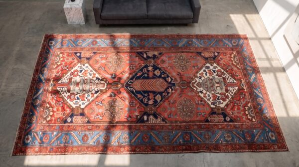 Rustic tribal geometric antique persian bakhtiari wool pile coral area rug 2 Rustic tribal geometric antique persian bakhtiari wool pile coral area rug (sku 21458) - styled overhead view