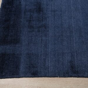 Edge of a navy blue handmade rug showing the fine loom lines (SKU OCU90NV8X10)